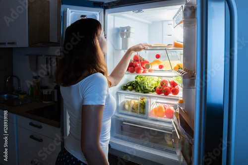 Woman Looking At Food In Refrigerator photo