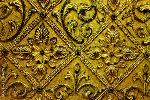 GOLDEN RELIEF DECORATION The art of low relief by using symmetrical flower ornament as a pattern on the gold plate to decorate the wall of the building. 