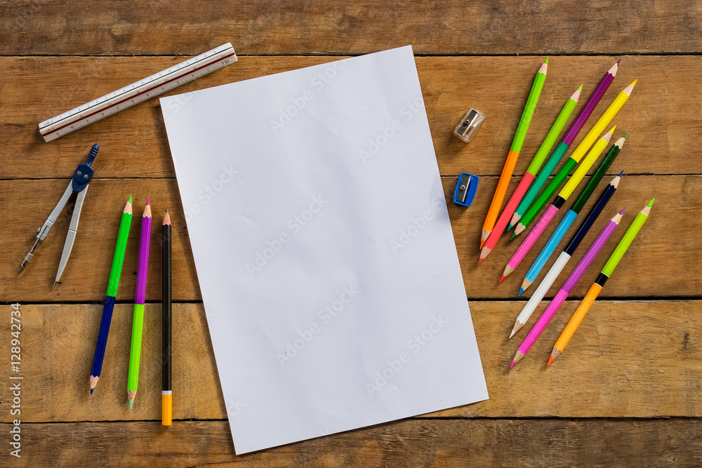Obraz premium Desk table with empty page paper, ruler and color pencils.Color pencils for drawing.