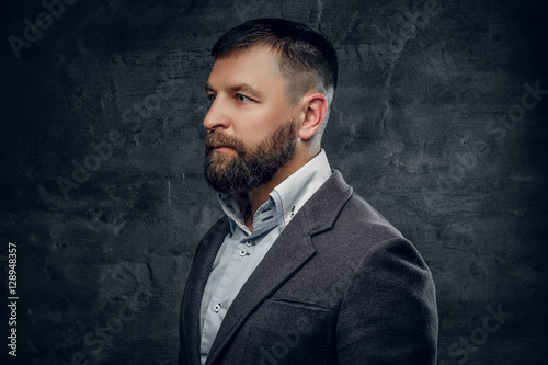 A bearded middle age male dressed in a woolen suit