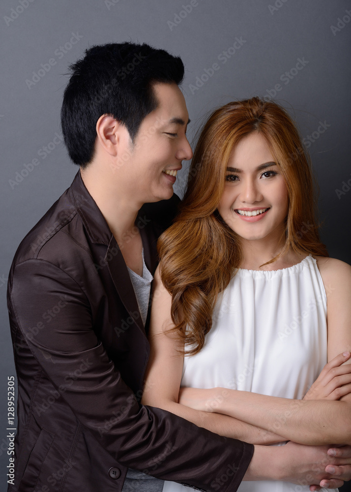 young lovely asian couple posing and smiling in studio for pre-w young lovely asian couple posing and smiling in studio for pre-w