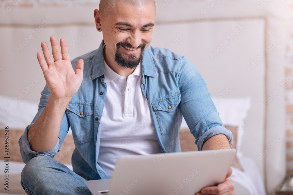 Fototapeta premium Smiling bearded man having the conversation via the Internet