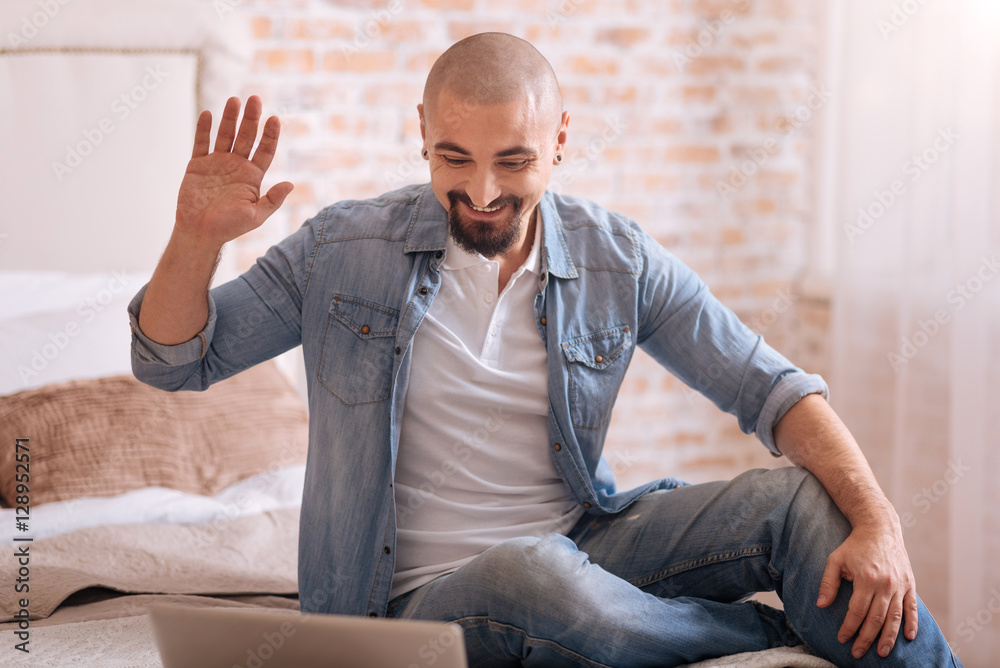 Delighted bearded man having the conversation via the Internet Delighted bearded man having the conversation via the Internet