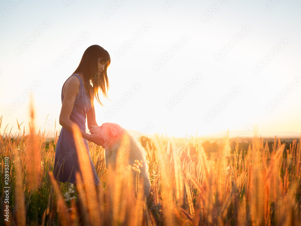woman playing with dog in field