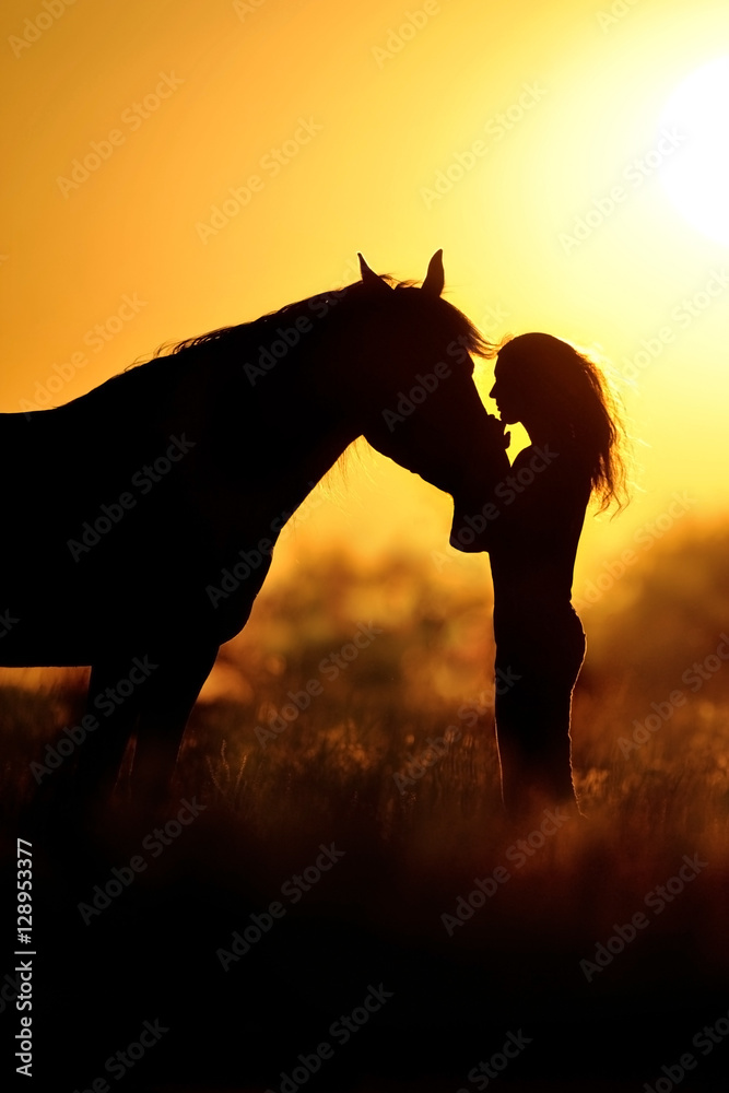 Fototapeta premium Girl and horse silhouette at sunset