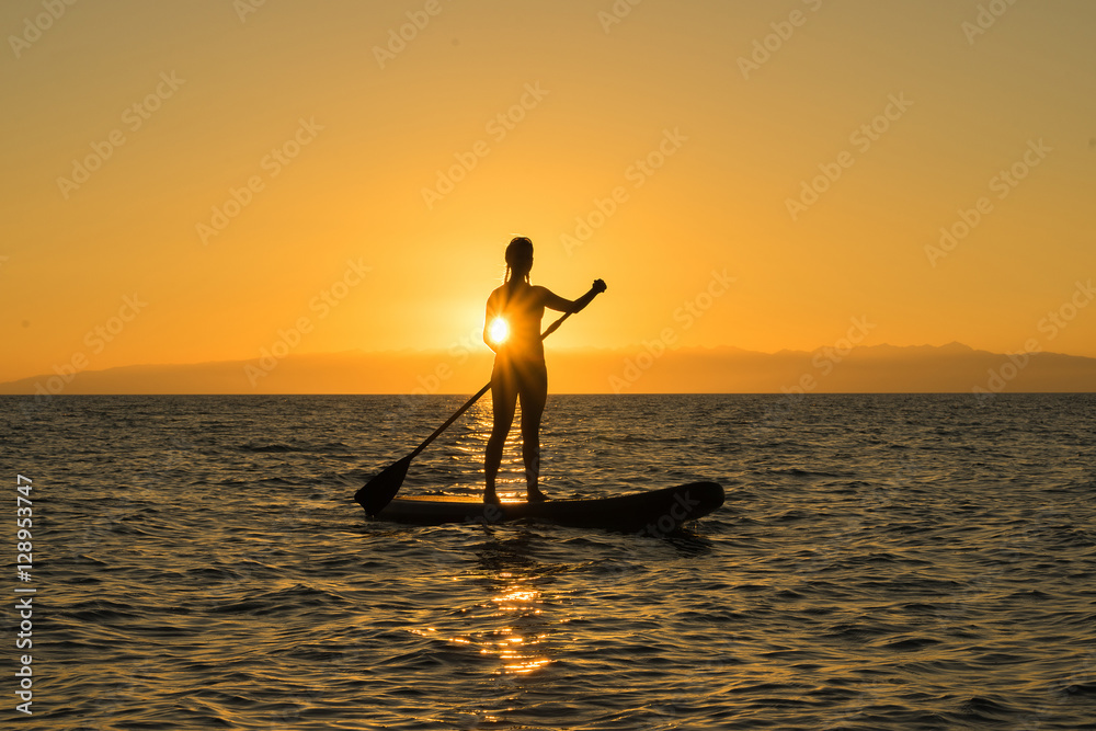 woman on paddle board sunset