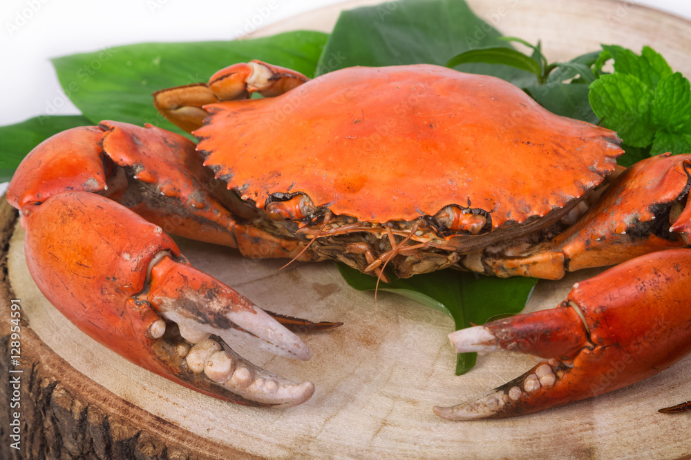 steamed crab on wooden server board with herbs and spices