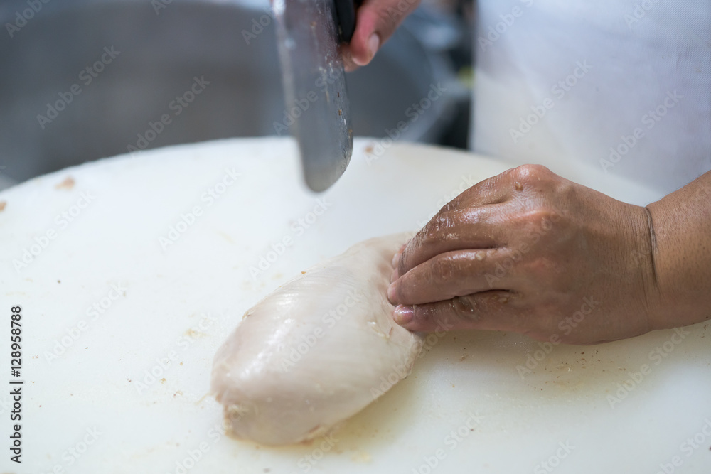 Fototapeta premium Food preparation. Man's hands cutting chicken 