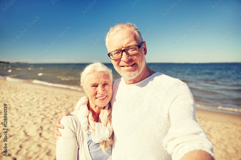 seniors taking picture with selfie stick on beach