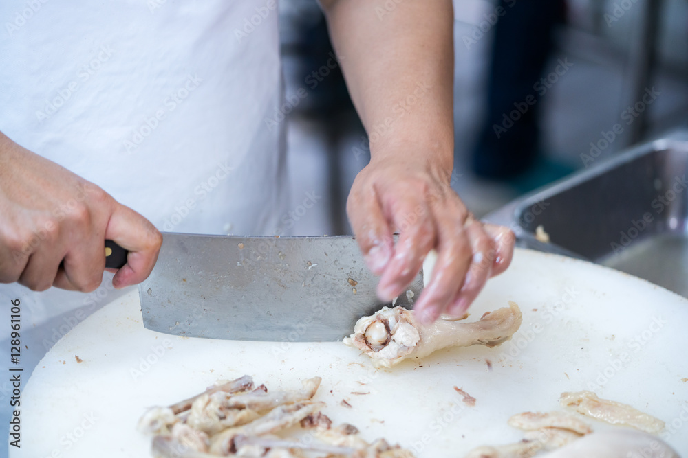 Man's hand cutting  chicken
