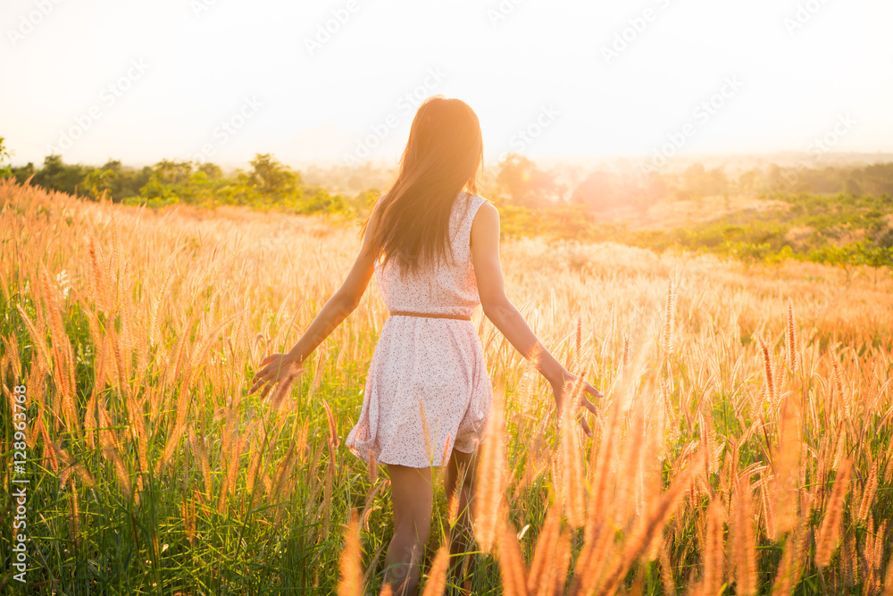 Beautiful girl in stylish summer dress walking in the field with flowers in sunlight,enjoying freedom feeling happy at sunset Beautiful girl in stylish summer dress walking in the field with flowers in sunlight,enjoying freedom feeling happy at sunset