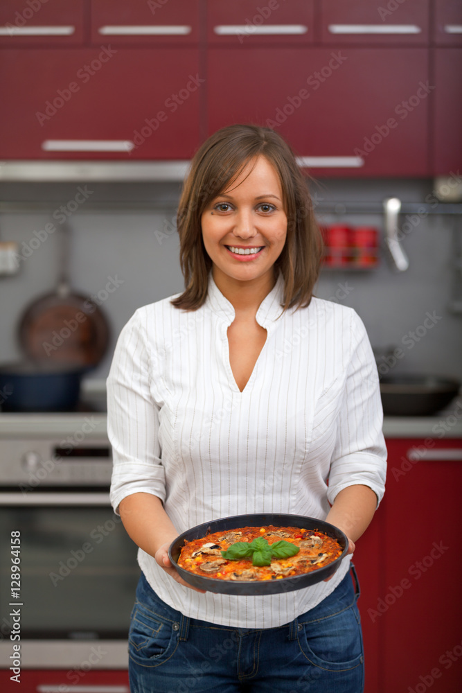 Young woman preparing homemade pizza - just after baking it