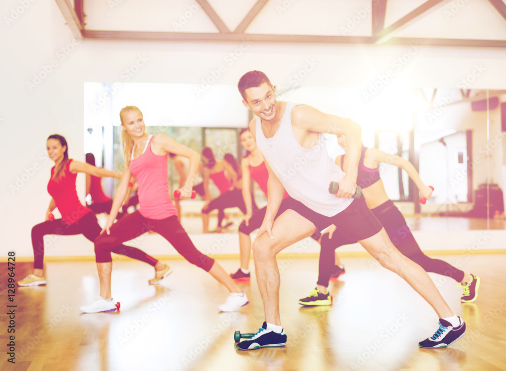 group of smiling people working out with dumbbells group of smiling people working out with dumbbells