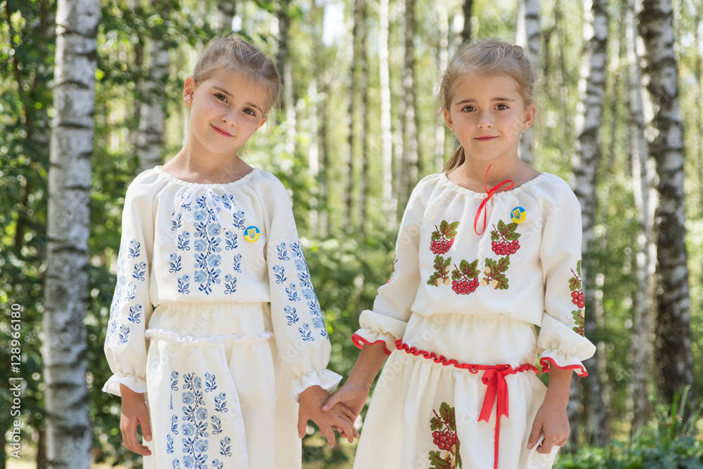 two little girls in traditional Ukrainian dress on a background two little girls in traditional Ukrainian dress on a background