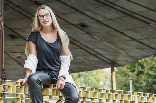 portrait of a young woman, blonde, glasses, outdoors in the park © romanets_v