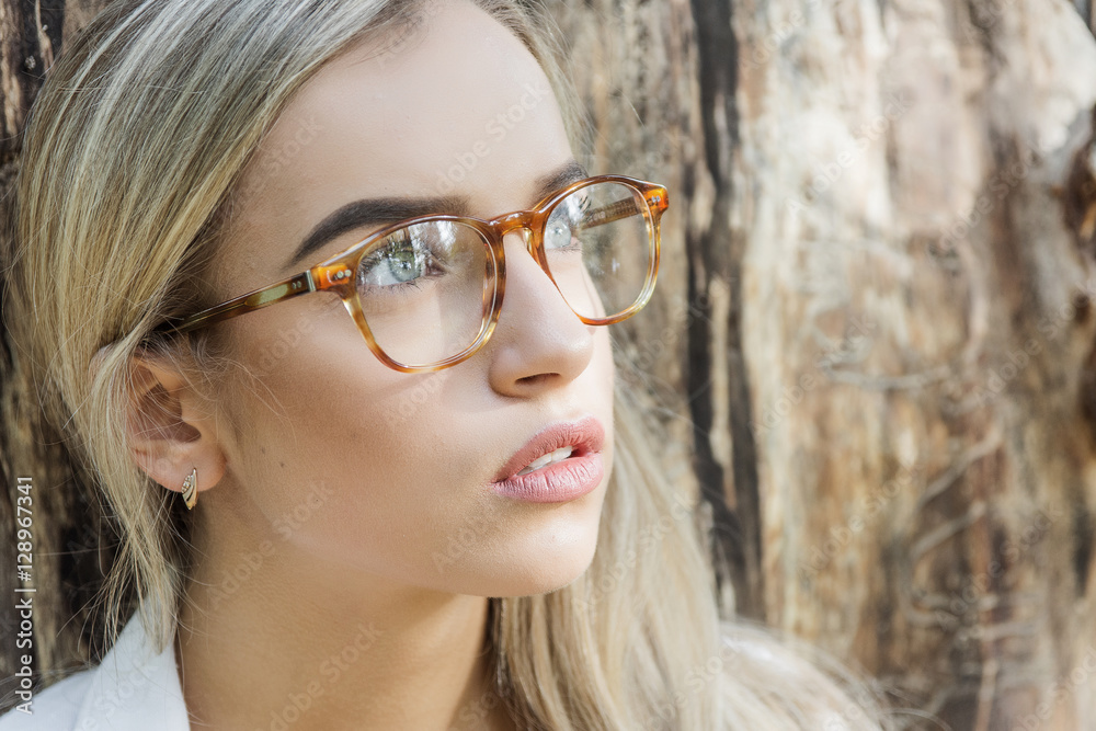 portrait of a young woman, blonde, glasses, outdoors in the park portrait of a young woman, blonde, glasses, outdoors in the park