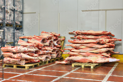 Frozen beef carcasses are stacked on pallets for cold storage.