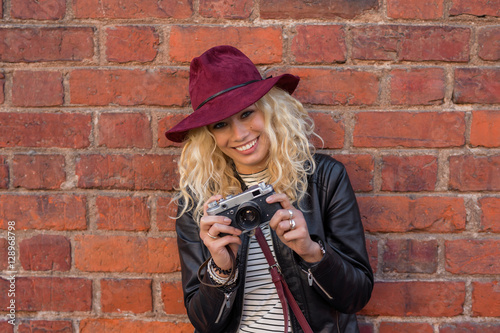 Happy woman taking pictures with vintage camera photo