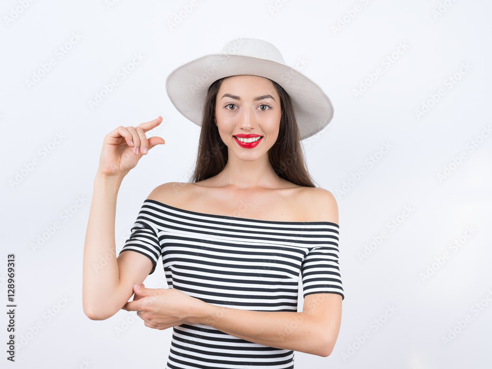 It is so small. studio portrait of pretty young woman showing sm It is so small. studio portrait of pretty young woman showing sm