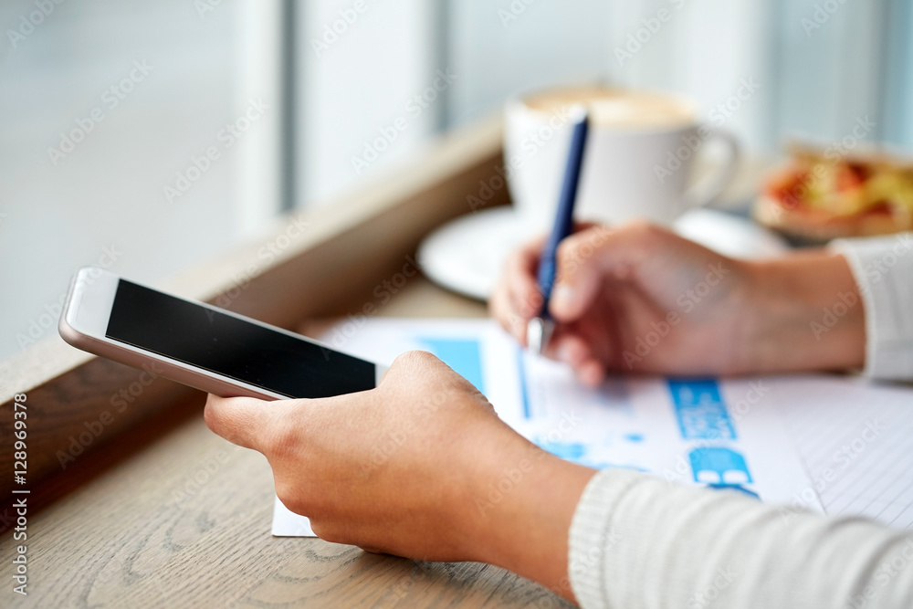 woman with smartphone and chart at cafe woman with smartphone and chart at cafe