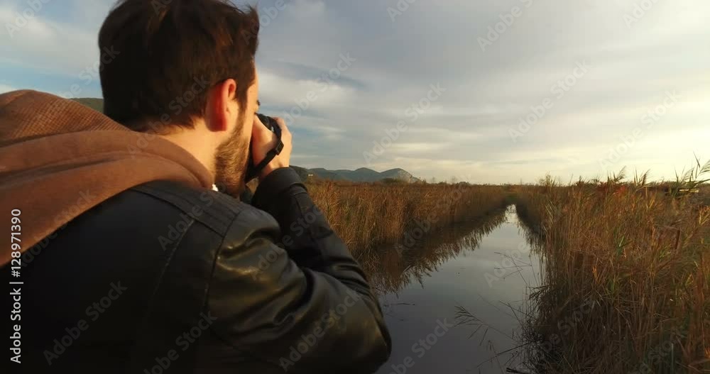 Young boy Italian Photographer is taking some still photo form a wooden bridge. Young boy Italian Photographer is taking some still photo form a wooden bridge.