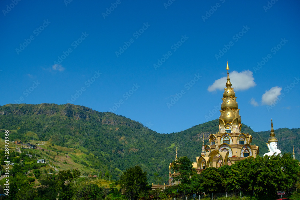 Big White Buddha Statue with mountain and blue sky background at Wat Phasornkaew in Thailand. Photo taken on: 29 November , 2016