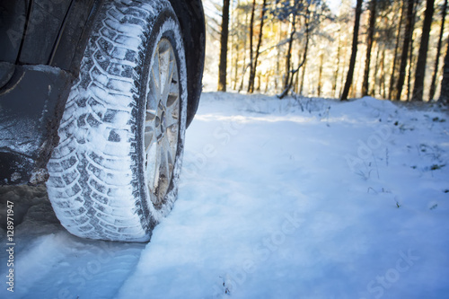 Car on the winter road in the wood. Winter tires