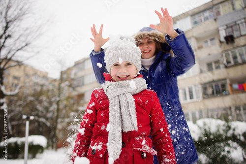 Mother with daughter cheerfully spend time in winter day.