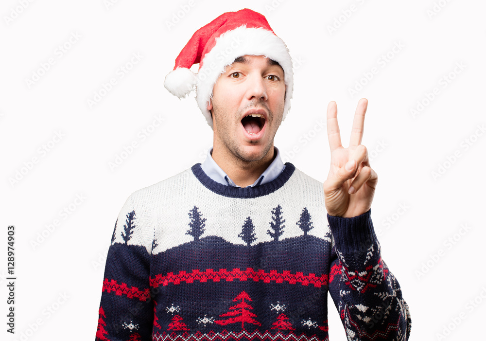 Happy young man with number two gesture at Christmas Happy young man with number two gesture at Christmas