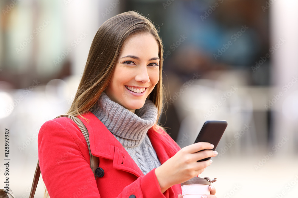 Girl with a phone looking at you in winter Girl with a phone looking at you in winter