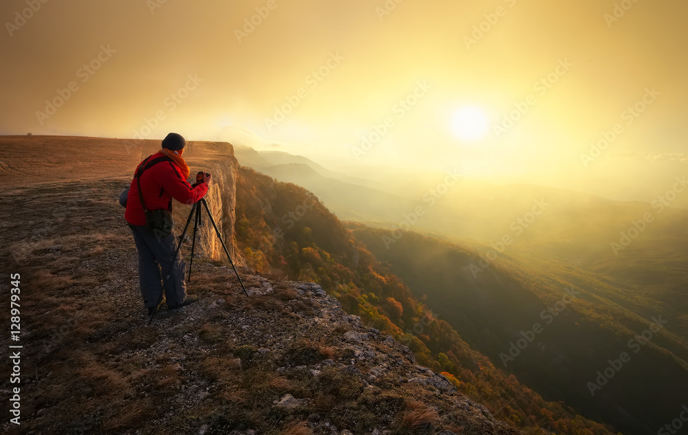 Professional on mountain. Nature photographer takes photos with