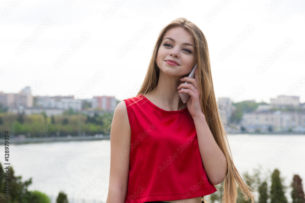 young beautiful woman talking phone outside