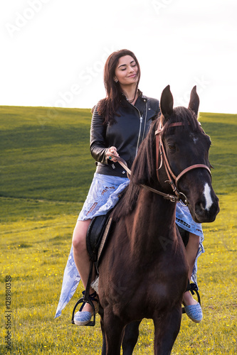 beautiful young woman riding a horse in a meadow © romanets_v