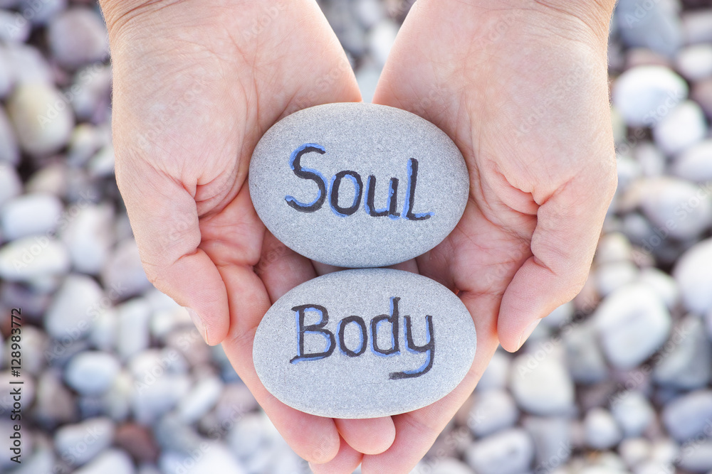 Woman holding stone with the words Soul and Body in her palms Woman holding stone with the words Soul and Body in her palms