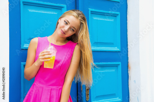 girl holding a lemonade on a blue door background