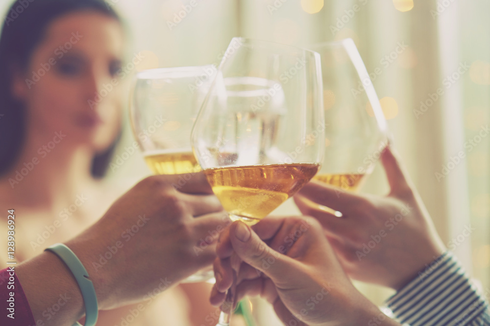 Clinking glasses of champagne in hands on bright lights background Clinking glasses of champagne in hands on bright lights background