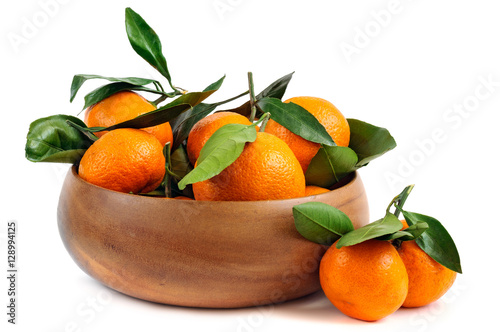 Obraz na płótnie Fresh tangerines with green leaves in a wooden bowl w salonie