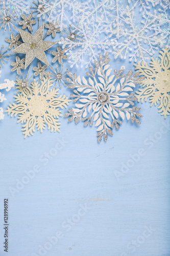 Silver decorative snowflakes on a blue wooden background. Christ
