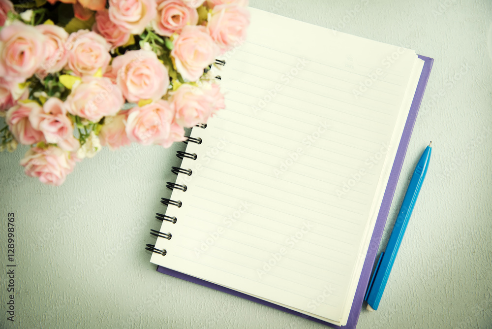 Naklejka premium Empty notebook with pen and flower. Abstract background.
