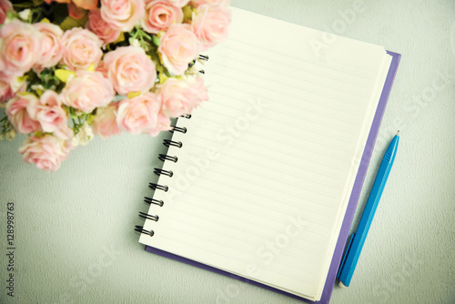 Empty notebook with pen and flower. Abstract background.