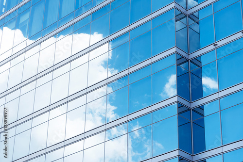 Close up of office building with reflection of blue sky and clou