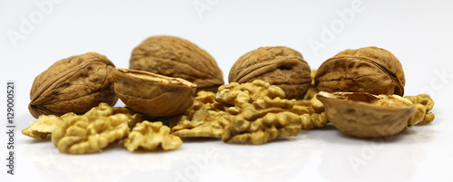 Walnut and a cracked walnut on the white background photo