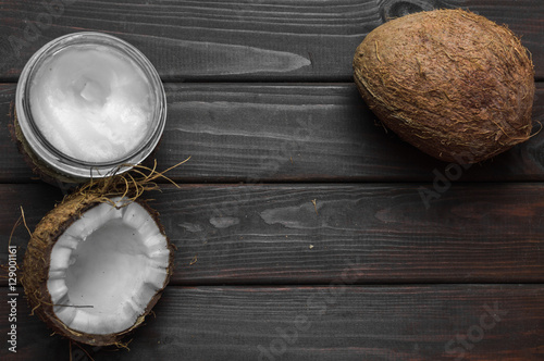 Fototapeta Naklejka Na Ścianę i Meble -  Coconut with coconut oil in jar on wooden background