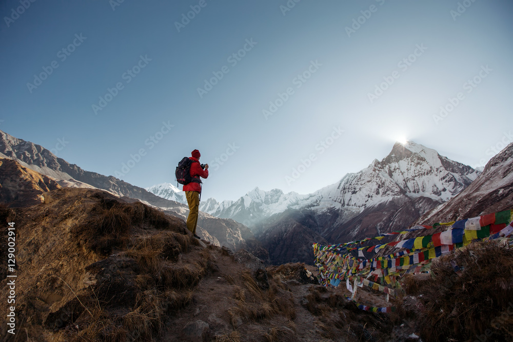 Φωτογραφία Tourist man watching and taking mobile photo of sunrise over the sacred mountain