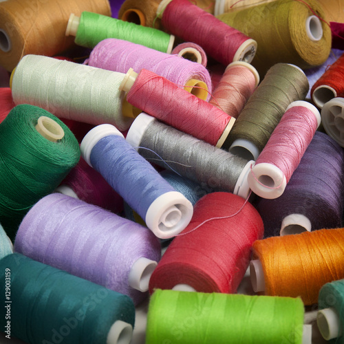 Snapshot of the pile of colorful spools of thread. Sewing conceptual background.