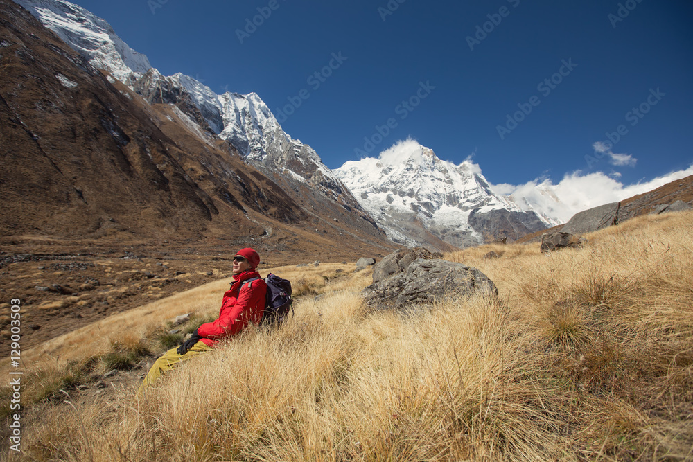Fototapeta premium Tourist man sitting and relax on Annapurna background. Mountain travel landscape in Nepal