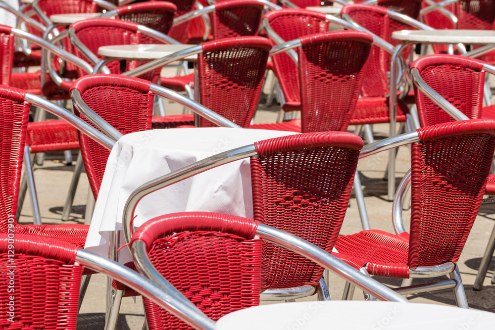 Close up from many red metal modern chairs and tables outdoor in restaurant in venedig Close up from many red metal modern chairs and tables outdoor in restaurant in venedig