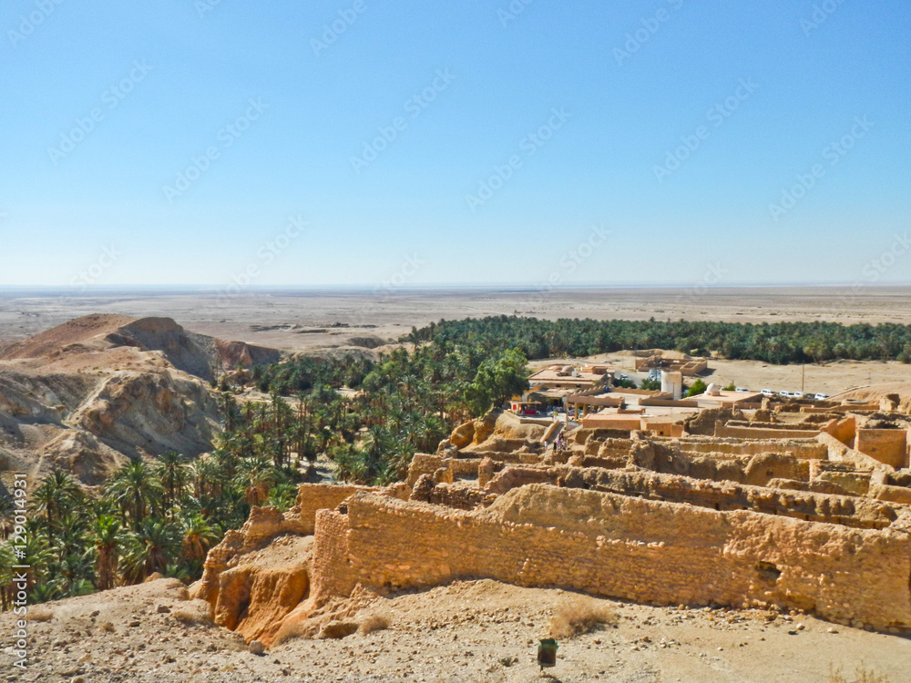 Oasis with ruins of old town in Sahara desert