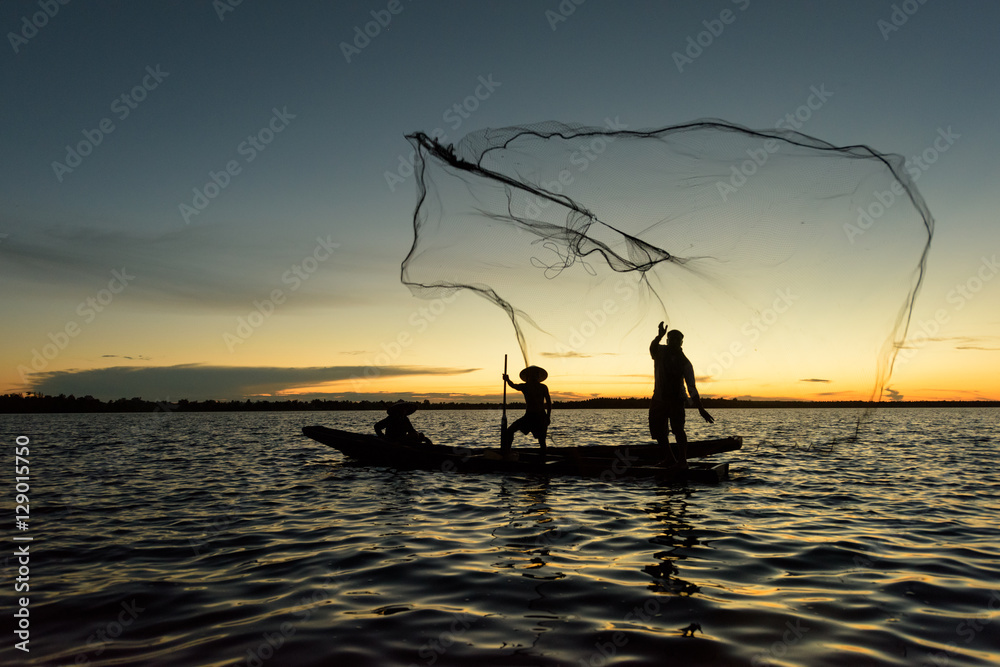 Silhouette of traditional fisherman throwing net fishing lake at
