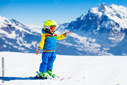 Ski and snow fun for child in winter mountains